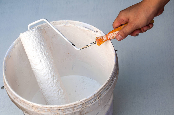 Hand holding rolling paint brush, ready to paint - Foto, imagen