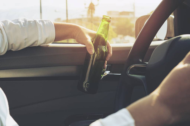 Woman drinking beer while driving a car - Foto, imagen