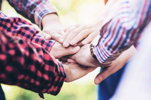 Ludzie grupy dołączyć ręce razem jako symbol jedności pracy zespołowej podczas ich aktywności spotkanie, aby osiągnąć swój ostateczny cel.  - Zdjęcie, obraz