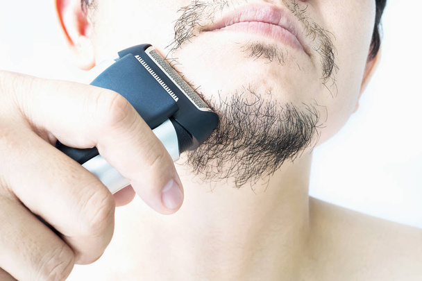 Man is using shaver - Photo, Image