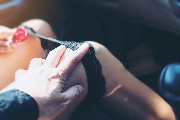 Man trekken panty voering van vrouw terwijl rijden of zitten in een auto - seks in auto gevaarlijk rijden gedragen concept - Foto, afbeelding