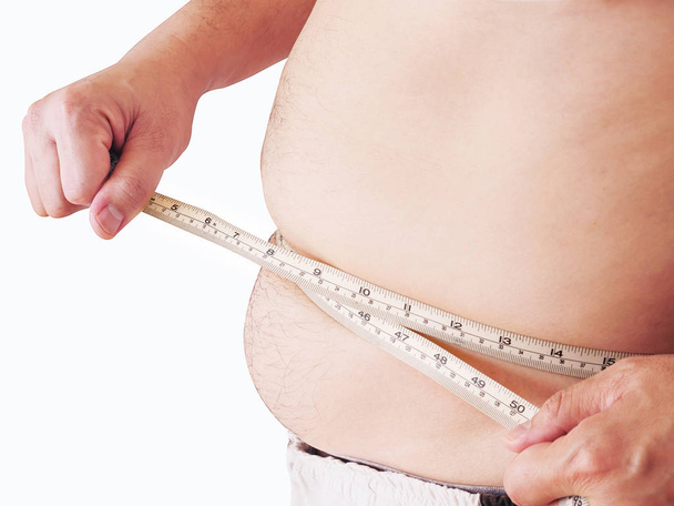 Fat man is measuring his belly using tape meter - dietary health concept - Foto, imagen