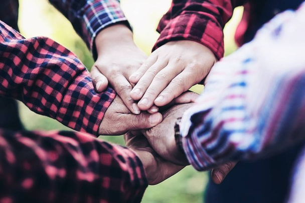 El grupo de personas une sus manos como símbolo de unidad de trabajo en equipo durante su actividad de encuentro para lograr su objetivo final
.  - Foto, imagen