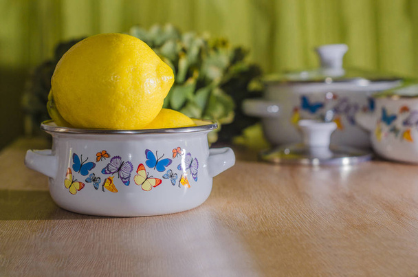 una olla con limones y alcachofas - Foto, Imagen