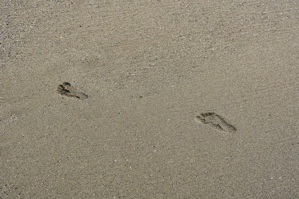 Gyermek lábnyomok kavicsos strand - Fotó, kép