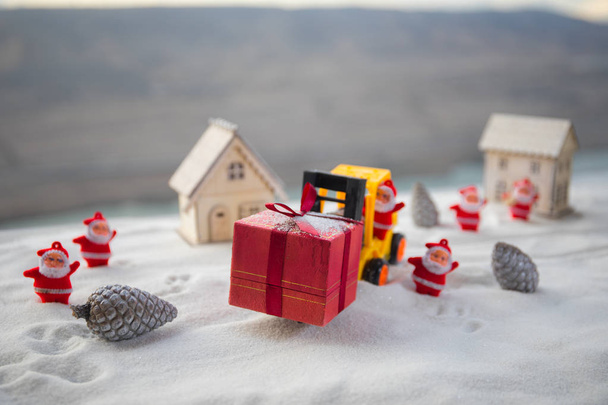 Miniatur-Geschenkbox von Gabelstapler-Maschine auf Schnee, bestimmtes Bild für Weihnachtsurlaub und glückliches neues Jahr Geschenk-Feier-Konzept. Selektiver Fokus - Foto, Bild