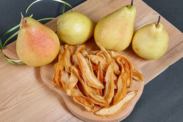 Dried pears and fresh pears on a black background. Healthy delicious food. - Valokuva, kuva