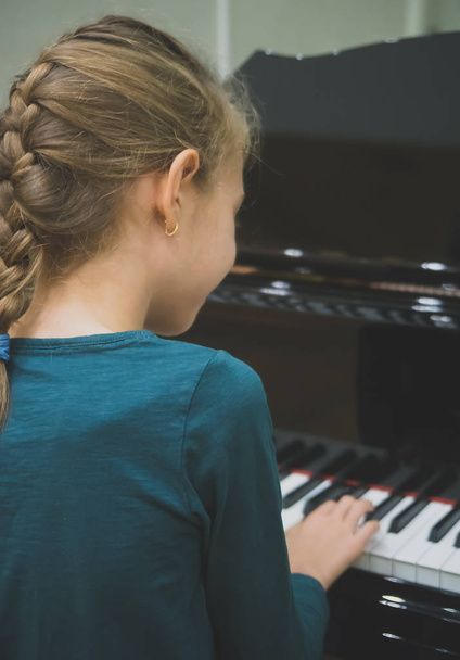 Little girl is playing the grand piano. - Foto, Imagem