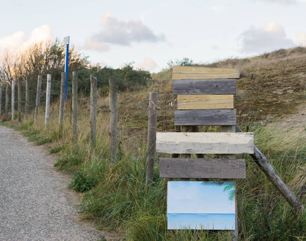 madera vacío camino en blanco punteros y letreros para poner su texto con hierba verde una valla y una carretera en el fondo - Foto, imagen