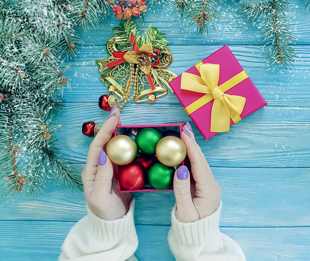 Noel ağacı dalı, kadın bir hediye kutusu mavi ahşap arka plan üzerinde eller - Fotoğraf, Görsel