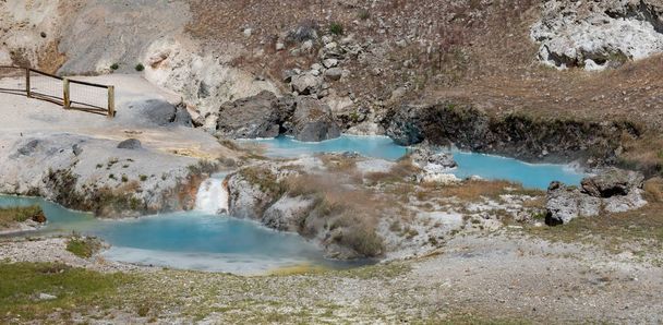 Hot Creek has dozens of natural hot springs bubbling up within the rocky walls of a river gorge and in the shadows of towering Eastern Sierra mountain peaks. It is a breathtaking place where boiling, bubbling water rich in dissolved mineral semerge - Photo, Image