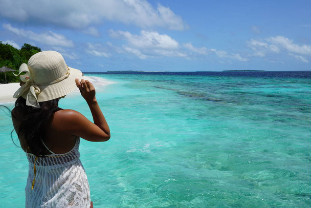 Mulher asiática jovem que está de pé contra a paisagem turquesa sob o céu azul na região Baa Atoll das Maldivas - Foto, Imagem