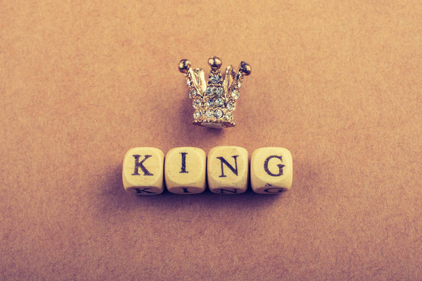 Tiny model crown beside the king wording on brown - Photo, Image