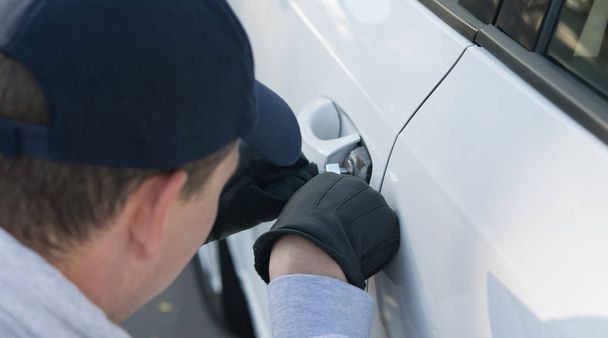 glove robber breaks the law, hacks the lock on the car to get inside - Fotó, kép