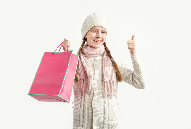 The girl with the pink gift bag raised her thumb up. Shopping for Christmas. - 写真・画像