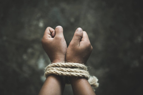 Hände gefesselt mit Seil eines vermissten Entführten, Misshandelten, Gewalt gegen Kinder, Opferkind in Schmerzen, Konzept des Menschenhandels. - Foto, Bild