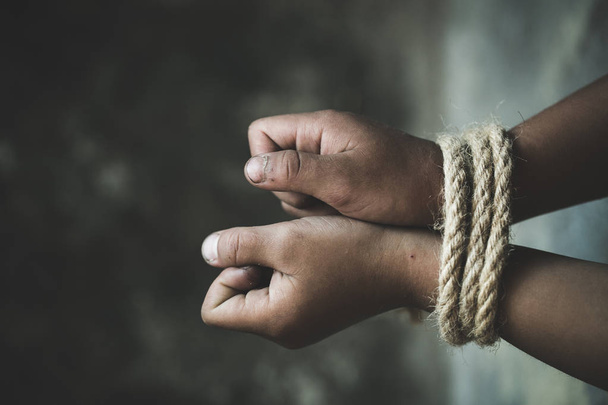 Slachtoffer jongen met handen vastgebonden met touw in emotionele stress en pijn, ontvoerd, misbruikt, gijzelaar, bang, beperkte, opgesloten, strijd, Stop geweld tegen kinderen en mensenhandel Concept. - Foto, afbeelding