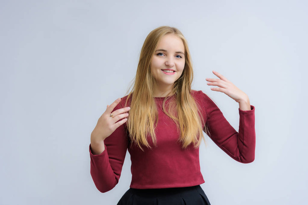 Concept portrait of a beautiful happy blonde girl on a white background smiling and talking with different emotions. She stands directly in front of the camera in various poses. - Фото, изображение