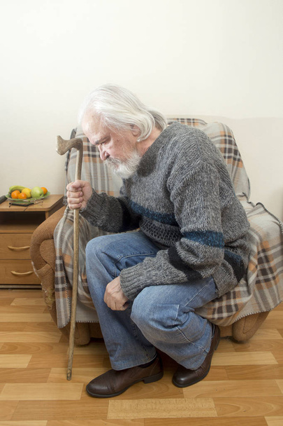 Smutny stary chory w sierocińcu dla osób w podeszłym wieku siedzi na krześle, sam i odbija się na ostatnich lat - Zdjęcie, obraz