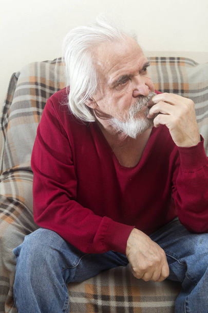 Красивий хворий старий з бородою і вусами з довгим білим волоссям у будинку престарілих сидить у кріслі і роздумує про минулі роки
 - Фото, зображення