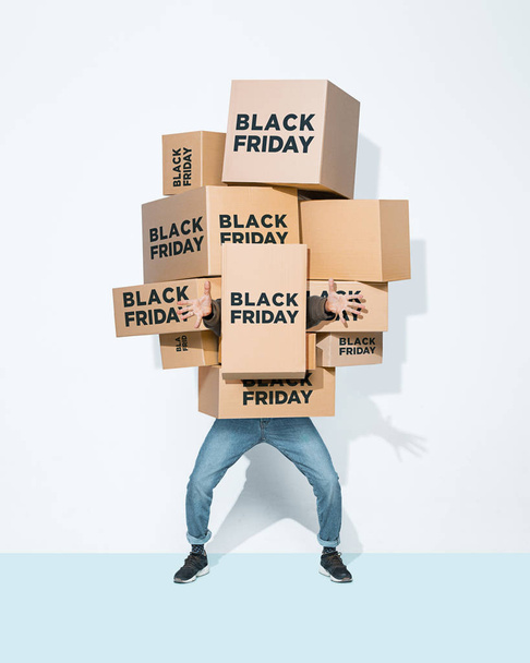 The lot of gift boxes in the hands of young man on white studio background. Cyber monday, shopping, black friday, sale, holiday, happy Christmas, sales season start concept - Fotoğraf, Görsel