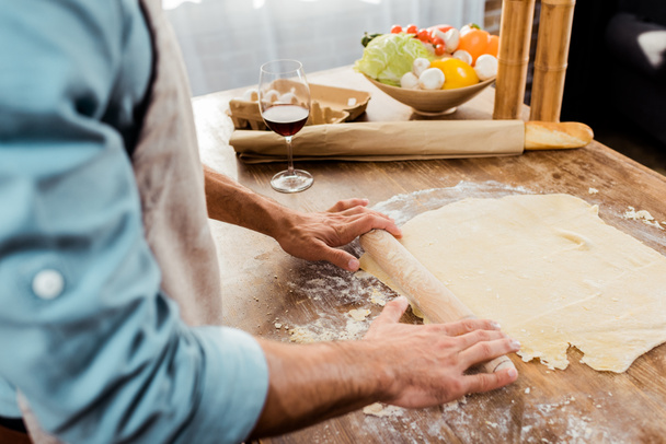 Oříznout záběr člověka s váleček připravuje těsto na pizzu v kuchyni - Fotografie, Obrázek
