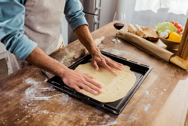 περικοπεί shot του ανθρώπου προετοιμασία πίτσα ζύμη σε ταψί - Φωτογραφία, εικόνα