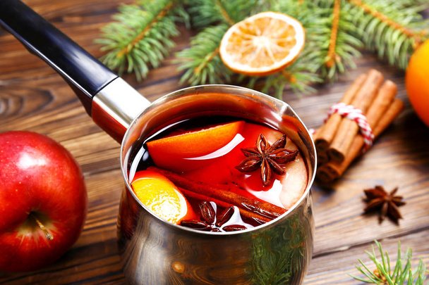 Christmas composition with mulled wine with its ingredients & spices on wooden textured table. Traditional drink on winter holiday season. Copy space, close up, top view, background. - Fotografie, Obrázek