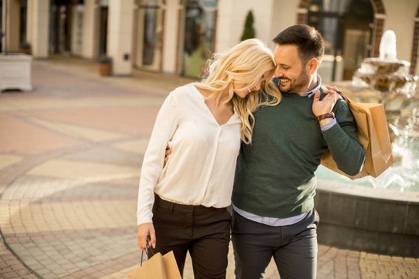 Portrait of happy loving couple with shopping bags and enjoying together - Foto, Imagen