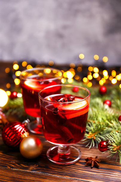 Christmas composition with mulled wine with its ingredients & spices on wooden textured table. Traditional drink on winter holiday season. Copy space, close up, top view, background. - Photo, Image