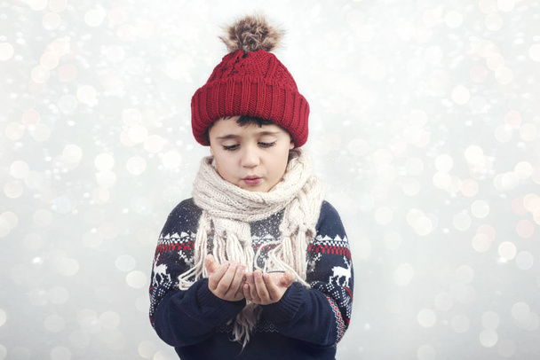 pequena criança sopra neve das mãos no Natal
 - Foto, Imagem
