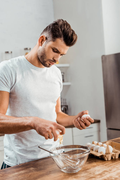 pohledný mladý muž připravuje omeletu k snídani - Fotografie, Obrázek
