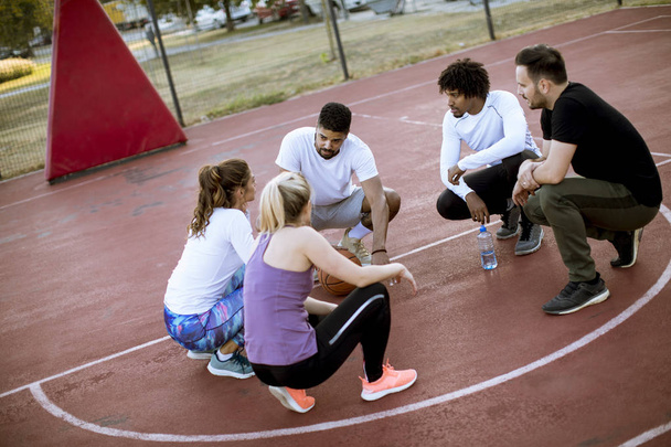 Basketbol oyuncu sahada birlikte dinlenme çok ırklı grubu - Fotoğraf, Görsel