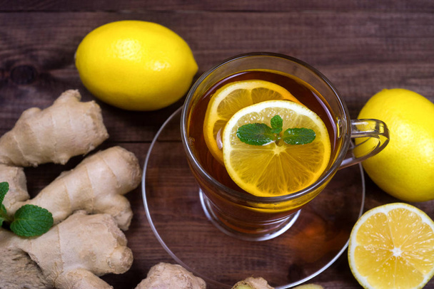 Thé au gingembre avec citron et menthe sur une table en bois.Le concept de santé.Boire riche en vitamines pour l'hiver par temps froid
. - Photo, image
