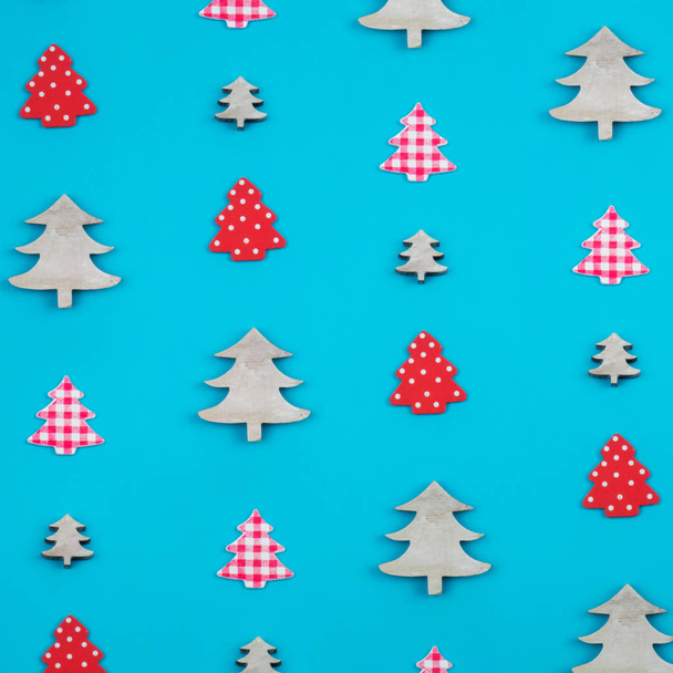 Creative and minimal  Christmas pattern made of christmas trees. Blue background. Flat lay top view. - Foto, Imagen
