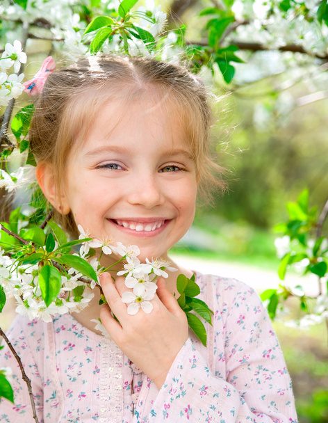 Little girl with bush blossoming tree - 写真・画像