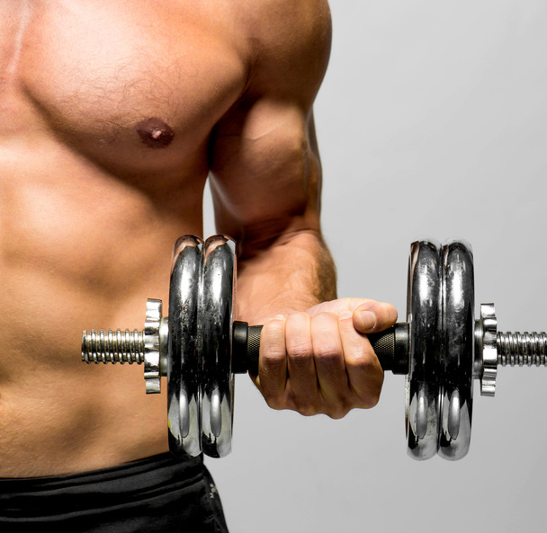 Powerful muscular man lifting weights - Fotoğraf, Görsel