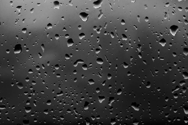 gotas de lluvia sobre un fondo de vidrio oscuro
 - Foto, Imagen