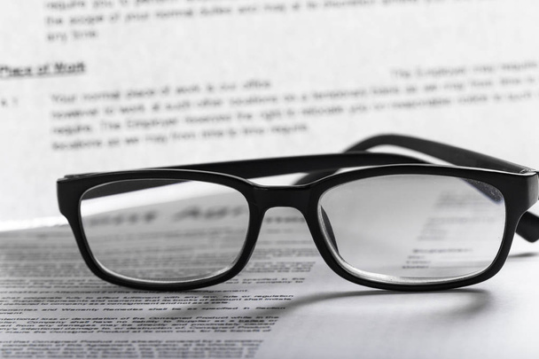 Close up of eyeglasses on document papers  - Fotó, kép