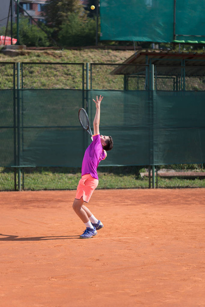 Young tennis player serving the ball - 写真・画像