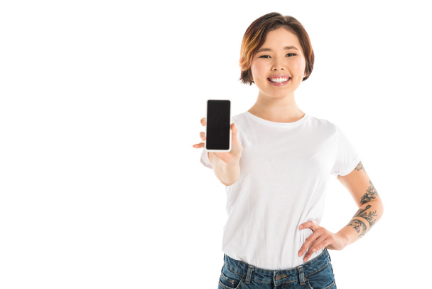 atractiva joven mujer que presenta teléfono inteligente con pantalla en blanco aislado en blanco
 - Foto, Imagen