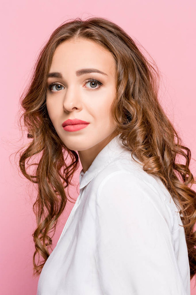 Serious business woman standing, looking at camera isolated on trendy pink studio background. Beautiful, young face. Female half-length portrait. Human emotions, facial expression concept - Foto, Imagem