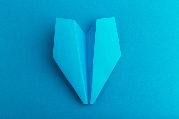 Flat lay of a paper plane on pastel blue color background - Фото, изображение