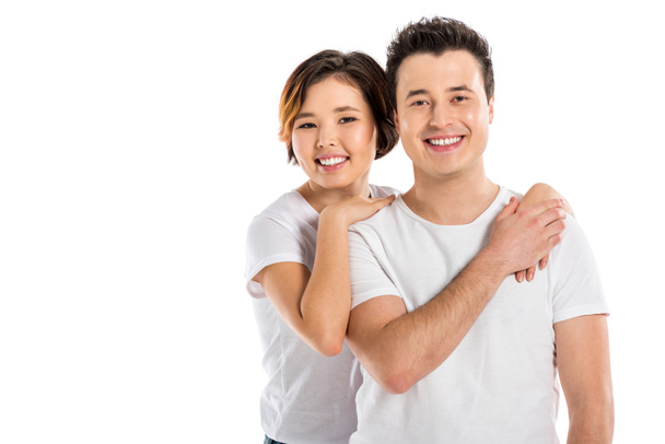 smiling portrait of young loving couple hugging and looking at camera isolated on white - Φωτογραφία, εικόνα