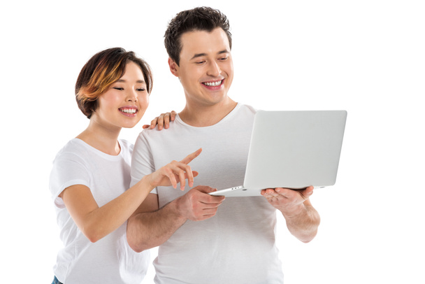 smiling young couple using laptop isolated on white - Foto, Imagen
