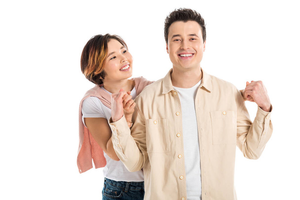 portrait of smiling couple in casual clothes holding hands and looking at camera isolated on white - Photo, Image