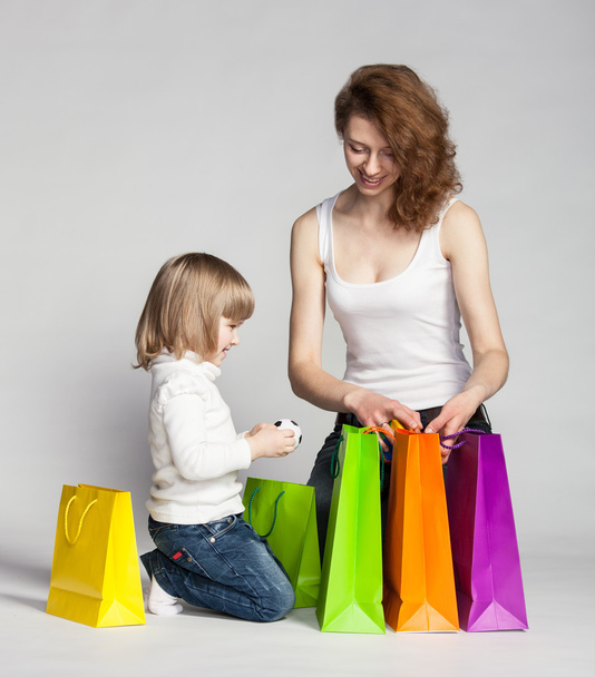 Little girl with her mother looking inside shopping bags - Φωτογραφία, εικόνα