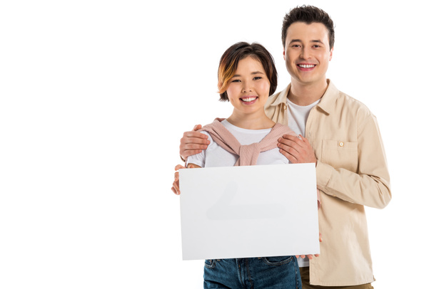 happy husband and wife in casual clothes looking at camera and holding blank board isolated on white - Photo, Image