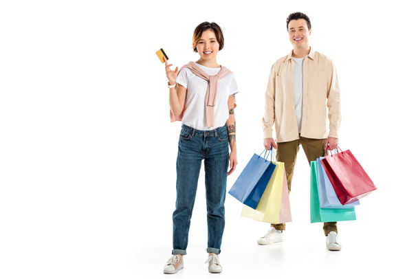 happy husband holding shopping bags while wife presenting credit card  - Photo, Image