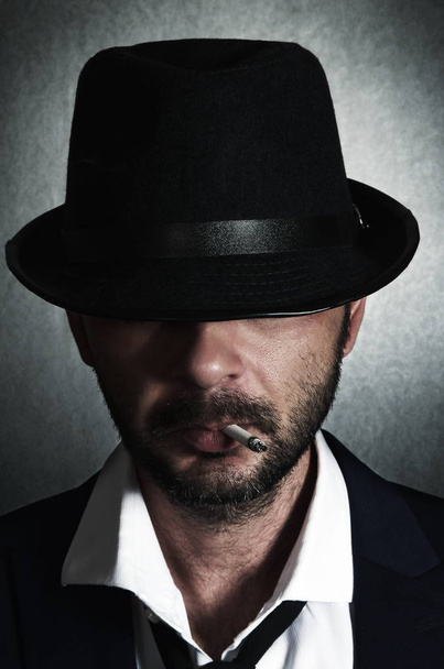 Homem retrô com o chapéu e cigarro
 - Foto, Imagem